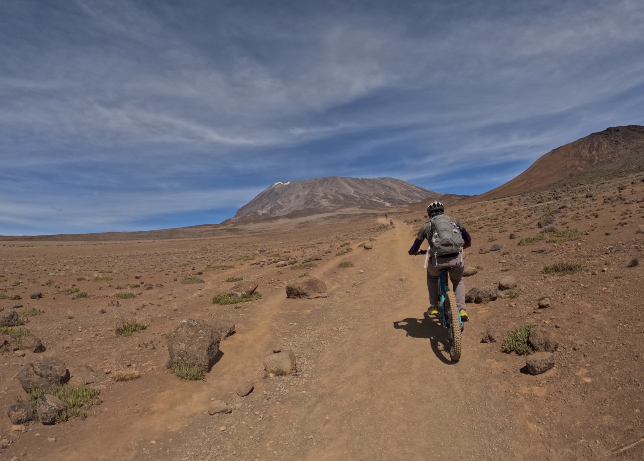 A mountain biker riding across a high-altitude volcanic landscape